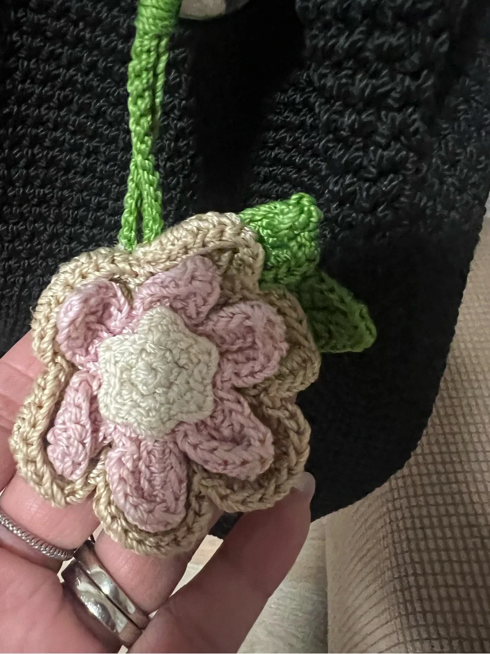 The Sak Black Knit Drawstring Backpack with Pink Floral Charm